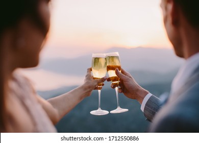 couple drink champagne at sunset. Honeymoon couple drink champagne at sunset together outdorrs with mountains view.