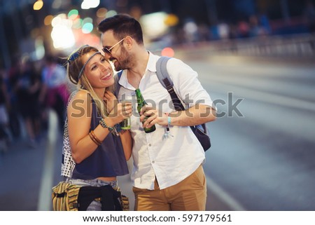 Couple drinking alcohol at night in city before festival