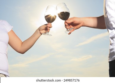 A Couple Drinking A Bottle Of Red Wine Outside