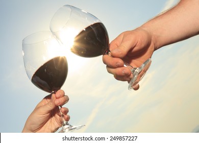 A Couple Drinking A Bottle Of Red Wine Outside