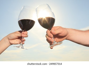 A Couple Drinking A Bottle Of Red Wine Outside