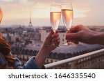 couple drinking champagne or wine in Paris luxurious restaurant with view of Eiffel tower, luxury romantic getaway honeymoon, cheers