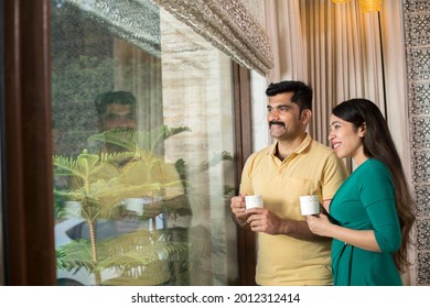 Couple drinking coffee and admiring view from balcony - Powered by Shutterstock