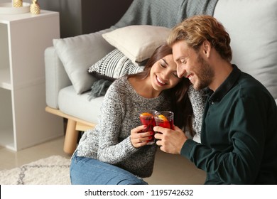 Couple Drinking Delicious Mulled Wine At Home