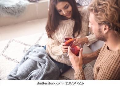 Couple Drinking Delicious Mulled Wine At Home