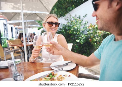 Couple drinking white wine at lunch while on summer vacation - Powered by Shutterstock