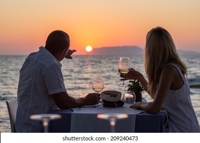 Couple Drinking Wine At Sea Beach Restaurant At Sunset