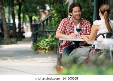 Couple drinking wine at sidewalk cafe