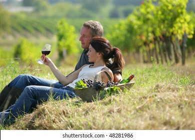 Couple Drinking Wine In Vineyard