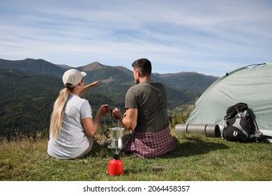 Couple With Drinks Enjoying Mountain Landscape Near Camping Tent, Back View