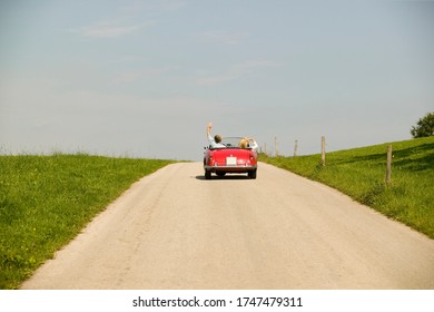 Couple Driving Convertible In Countryside