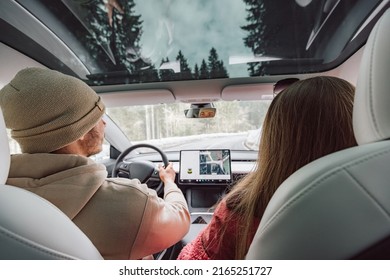 Couple Driving In Electric Car Go On A Road Trip.