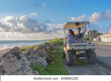 couple driving a golf cart at tropical beach on Isla Mujeres, Mexico