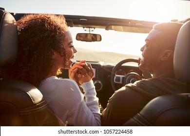 Couple driving look at each other, hold hands, passenger POV