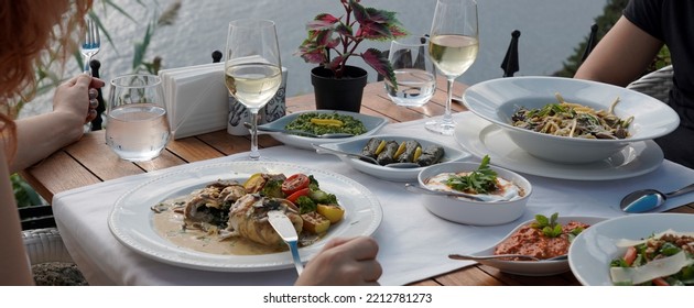 Couple Eating Fish Dinner At A Restaurant By The Sea
