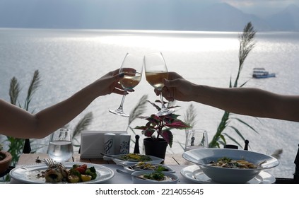 Couple Eating Fish Dinner At A Restaurant By The Sea
