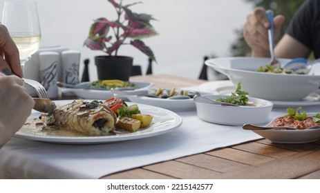 Couple Eating Fish Dinner At A Restaurant By The Sea
