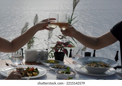 Couple Eating Fish Dinner At A Restaurant By The Sea
