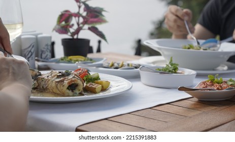 Couple Eating Fish Dinner At A Restaurant By The Sea