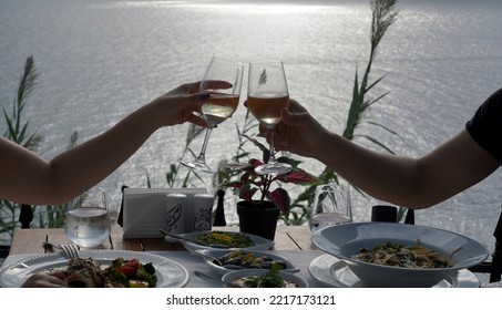 Couple Eating Fish Dinner At A Restaurant By The Sea