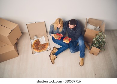 Couple Eating Pizza On The Floor, Moving In In A New Home