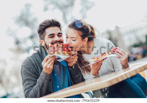 屋外でピザを食べるカップル 彼らはピザを共有し 食べている の写真素材 今すぐ編集