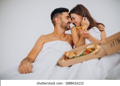 Couple Eating Pizza Together In Bed