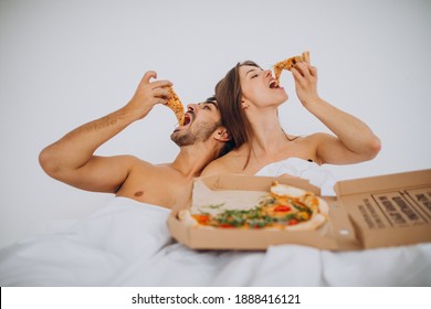 Couple Eating Pizza Together In Bed