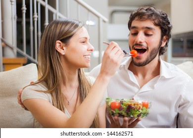 Couple Eating A Salad In The Living Room