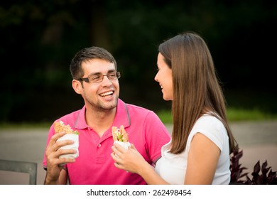 Couple Eating Sandwich And Talking Outdoor In Nature