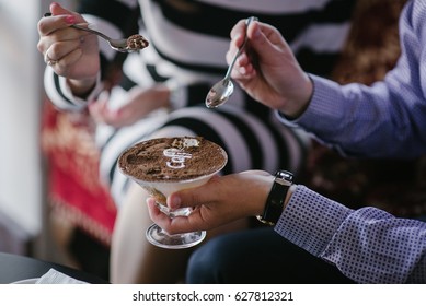 Couple Eating Tiramisu Dessert In Glass Cup. Close-up