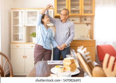 A Couple Elder Or A Retired Older Man And Woman Happy Cooking With Breakfast In The Morning, Holiday Family Relaxing In The Kitchen, Lovely Grandparent Dancing