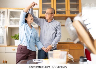 A Couple Elder Or A Retired Older Man And Woman Happy Cooking With Breakfast In The Morning, Holiday Family Relaxing In The Kitchen, Lovely Grandparent Dancing