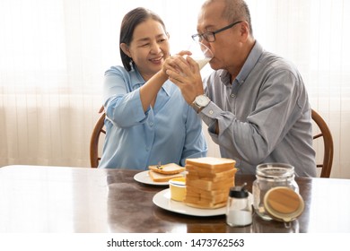 A Couple Elder Or A Retired Older Man And Woman Happy Cooking With Breakfast In The Morning, Holiday Family Relaxing In The Kitchen, Lovely Grandparent Drinking A Glass Of Milk