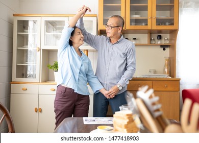 A Couple Elder Or A Retired Older Man And Woman Happy Cooking With Breakfast In The Morning, Holiday Family Relaxing In The Kitchen, Lovely Grandparent Dancing