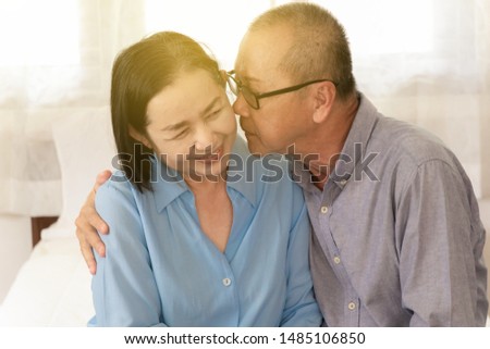 Couple Elderly man kisses cheek woman showing happy and love the morning in bedroom