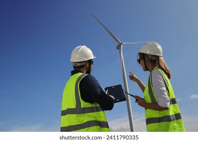 A couple of  Electric engineers working together at a wind turbine farm. - Powered by Shutterstock