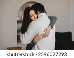 Couple embraces in a cozy indoor setting during a quiet moment