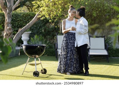 Couple embracing at barbecue grill in garden - Powered by Shutterstock