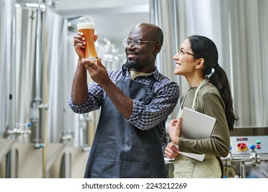 Couple of engineers examining beer after brewing - Powered by Shutterstock