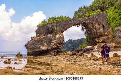 Couple enjoy at Neil island beach with natural rock formations at Andaman, India.