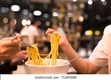 Couple Enjoy Noodles In Restaurant At Night