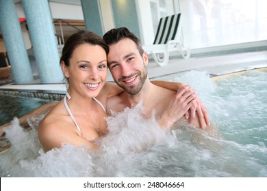 Couple enjoying bath in spa center jacuzzi