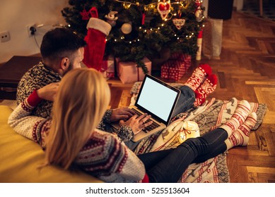 Couple enjoying Christmas mood while surfing the net together.