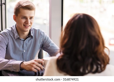 Couple Enjoying Coffee And Talking In Cafe