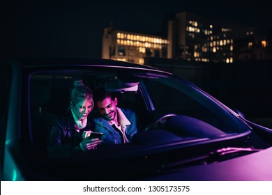 Couple Enjoying Dating In Car And Using Phone