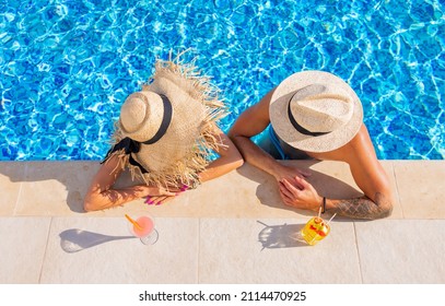 Couple Enjoying Drinks By The Pool, Overhead View