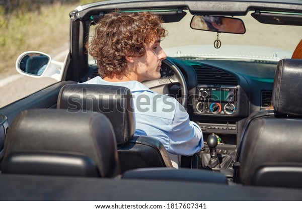 Couple enjoying a drive in a
convertible in summer road. Friends going on holidays. Italian
vacation serpentine roads, a redheaded woman and a beautiful young
man