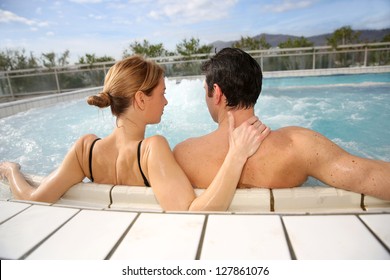 Couple enjoying jacuzzi in spa center