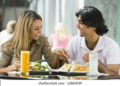 Couple enjoying lunch sitting at cafe table - Powered by Shutterstock